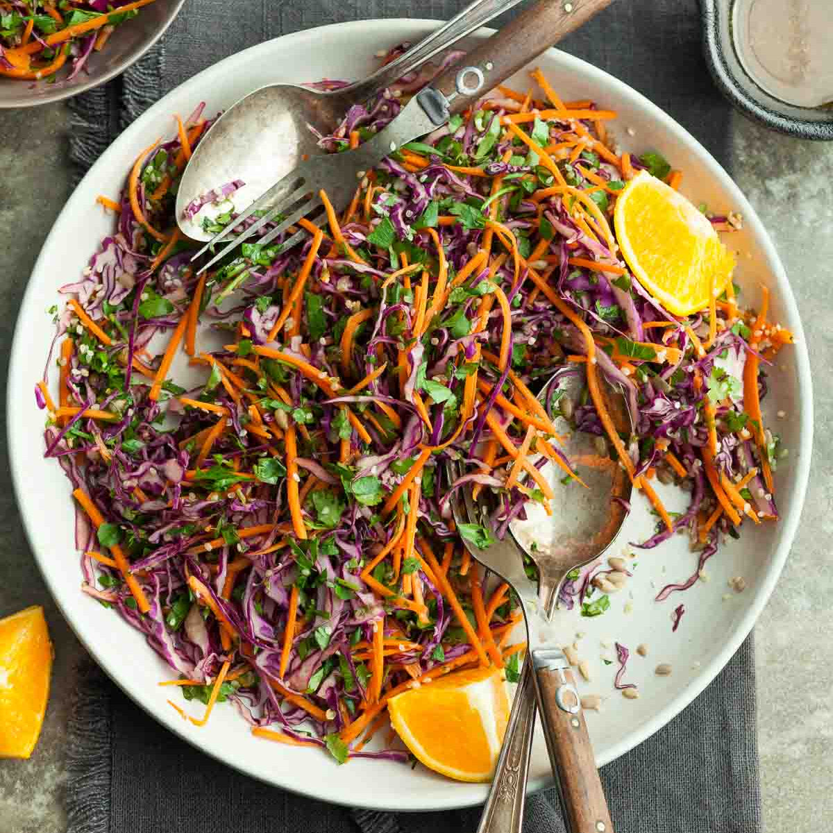 Sweet + tangy citrus slaw with red + green cabbage, carrots, spring onions, coriander, toasted seeds and a tangy lime + orange dressing (gf/vegan)