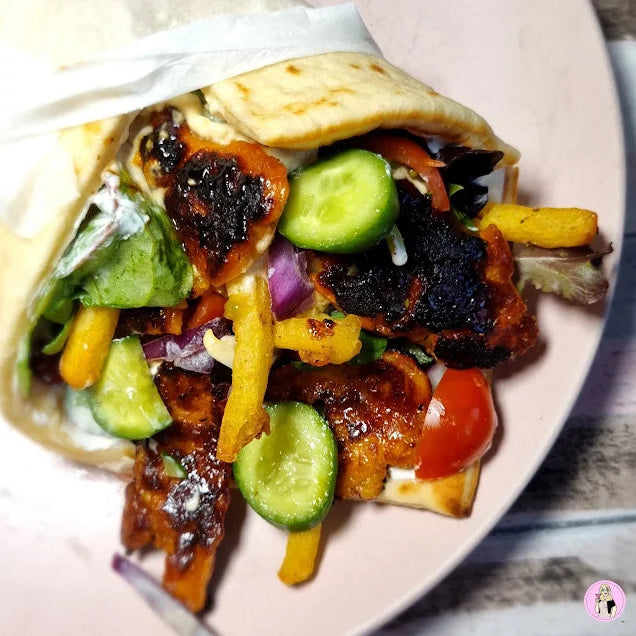 Sticky honey & lime halloumi Greek wrap with sticky honey + lime halloumi, cucumber, tomatoes, pickled red onion, greens + tzatziki (vegetarian)