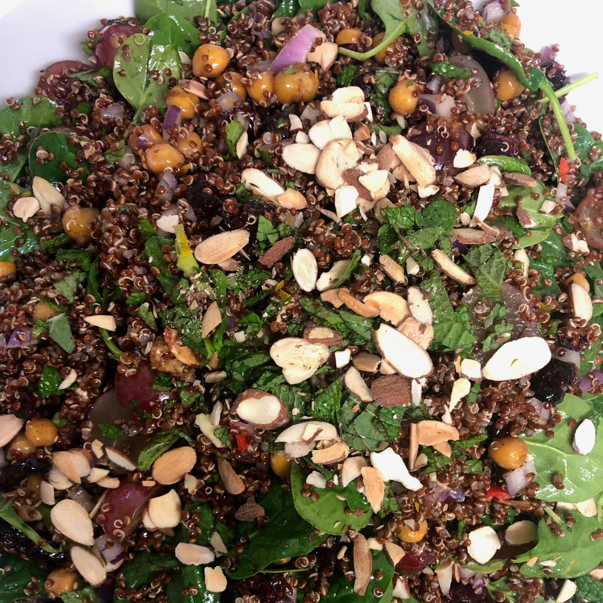 Grape + quinoa salad with roasted cinnamon chickpeas, baby spinach, grapes, cranberries, chilli, finely chopped red onions, mint, flaked almonds and a lemon dressing (gf/vegan) 
