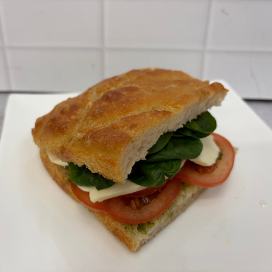 Pesto and mozzarella focaccia with pesto, fresh tomato, fresh mozzarella, basil + aioli on housemade focaccia.
