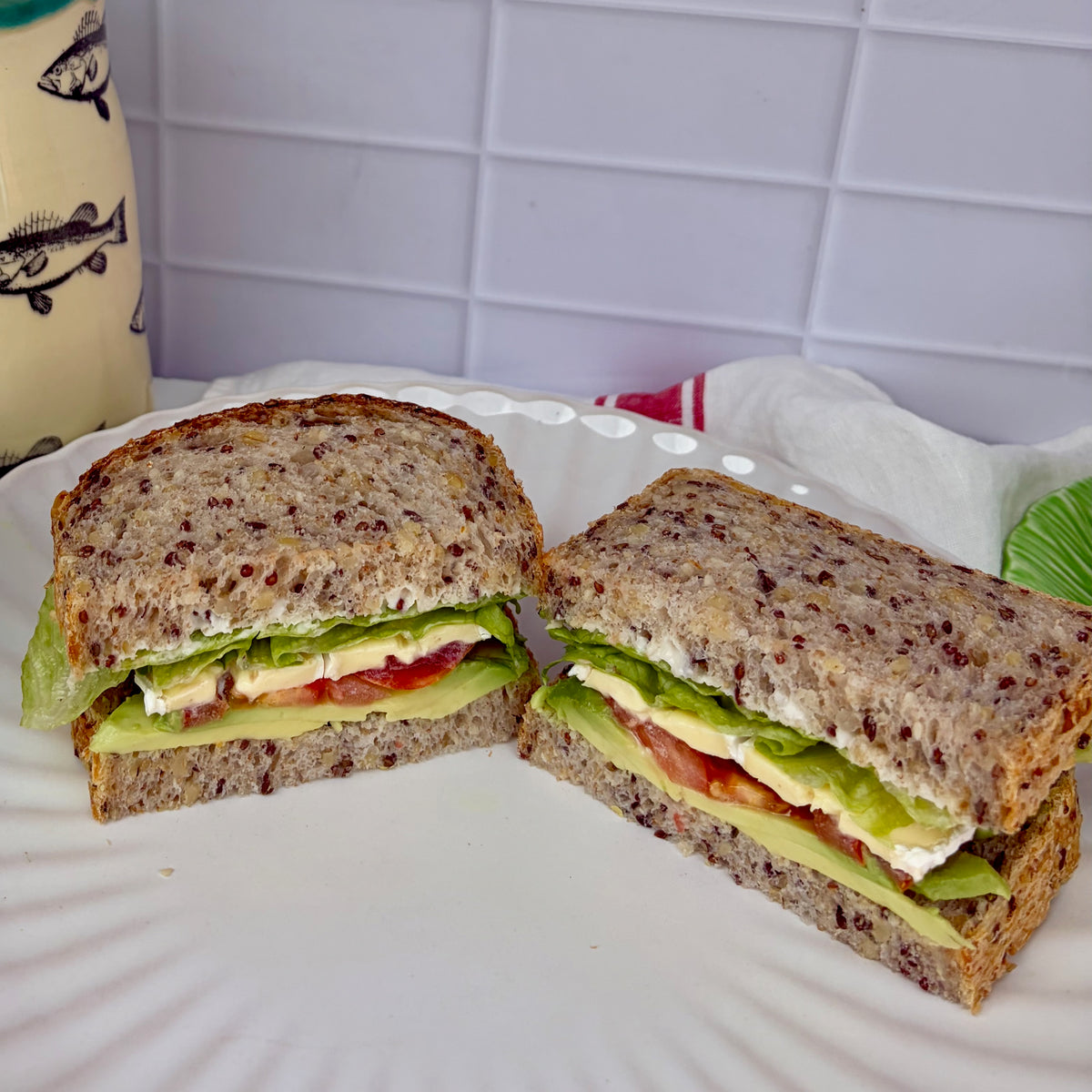 Avocado + tomato sandwich 
with sliced avocado, tomato, brie + lettuce sandwich on grain sourdough