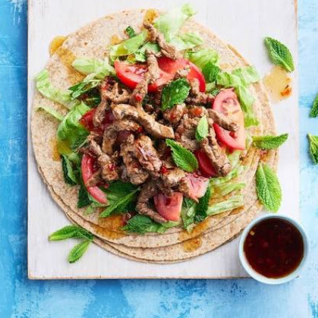 Thai beef wrap with grilled beef slices, tomato, mint, cucumber, crunchy lettuce and a spicy Thai dressing