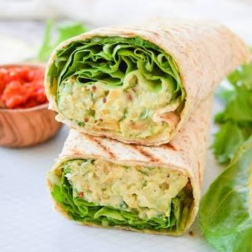 Chickpea + avocado wrap with aioli, smashed chickpeas, sliced avocado, sprouts and greens with a dijon vinaigrette